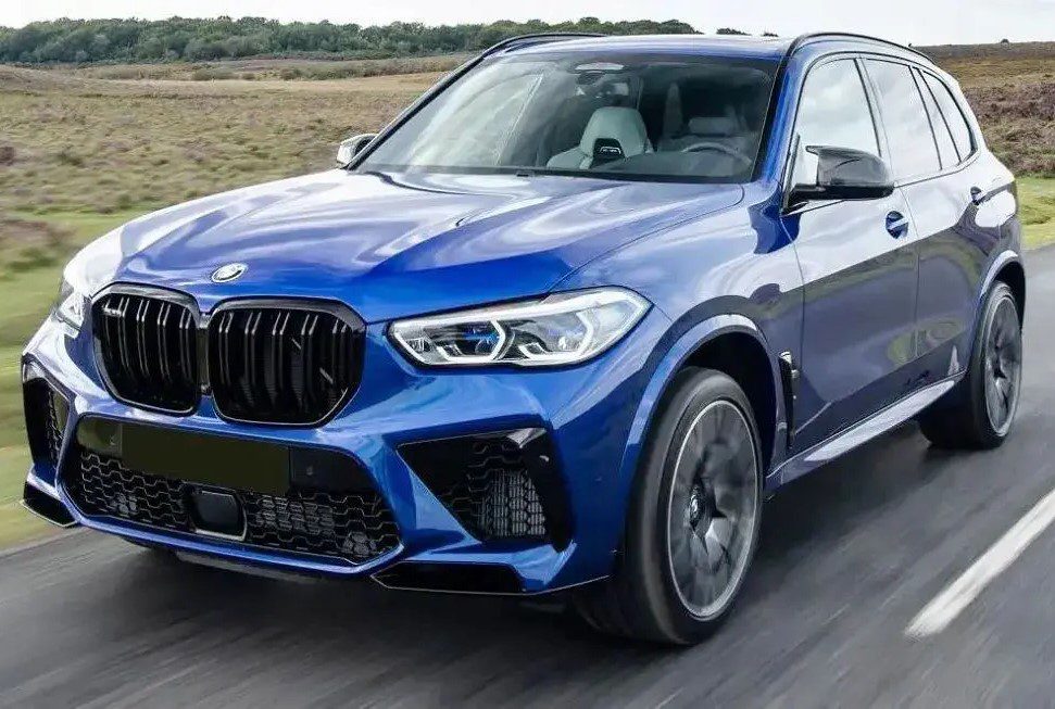 A blue bmw is driving down the road